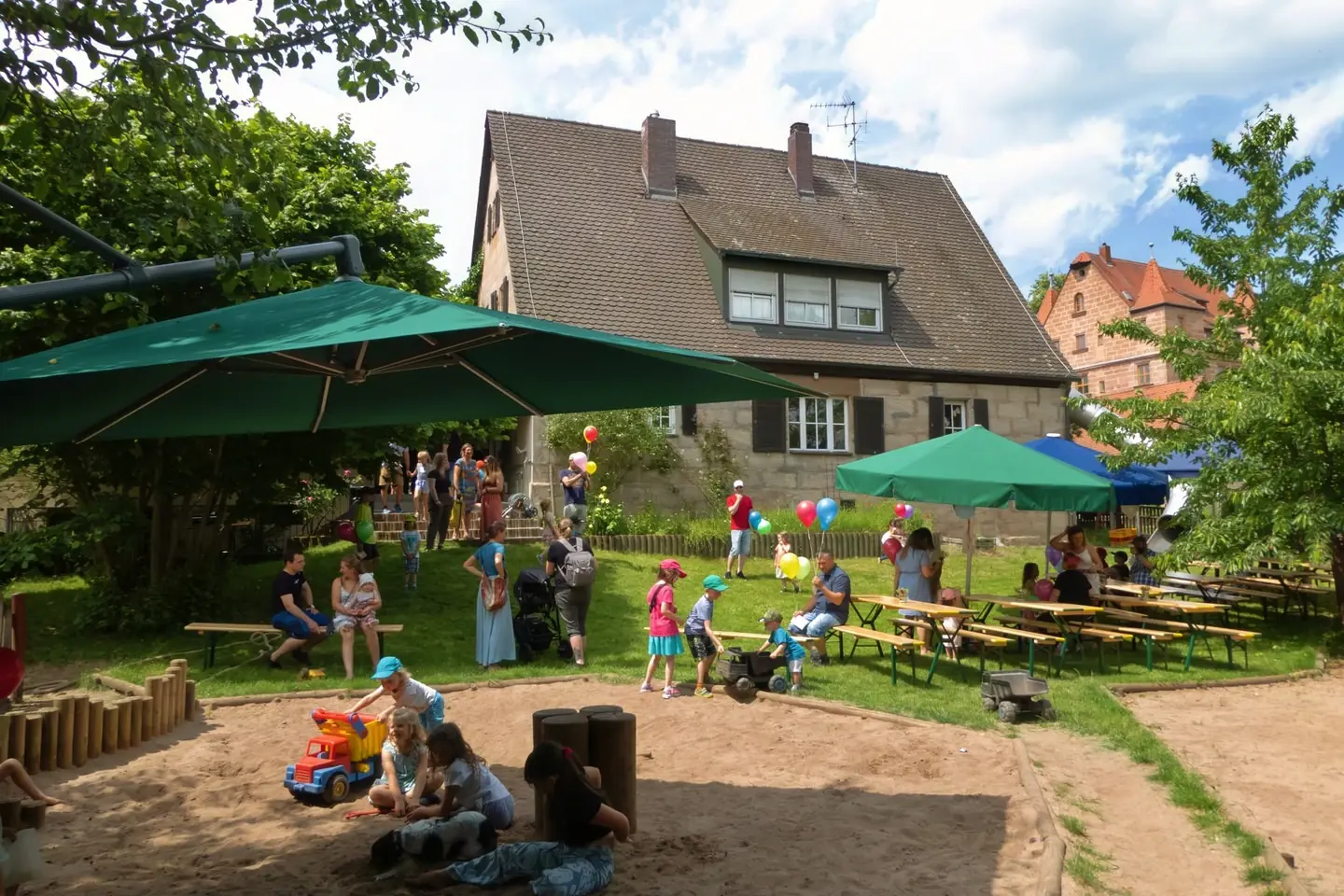 Kinder spielen im Garten unter dem Sonnensegel
