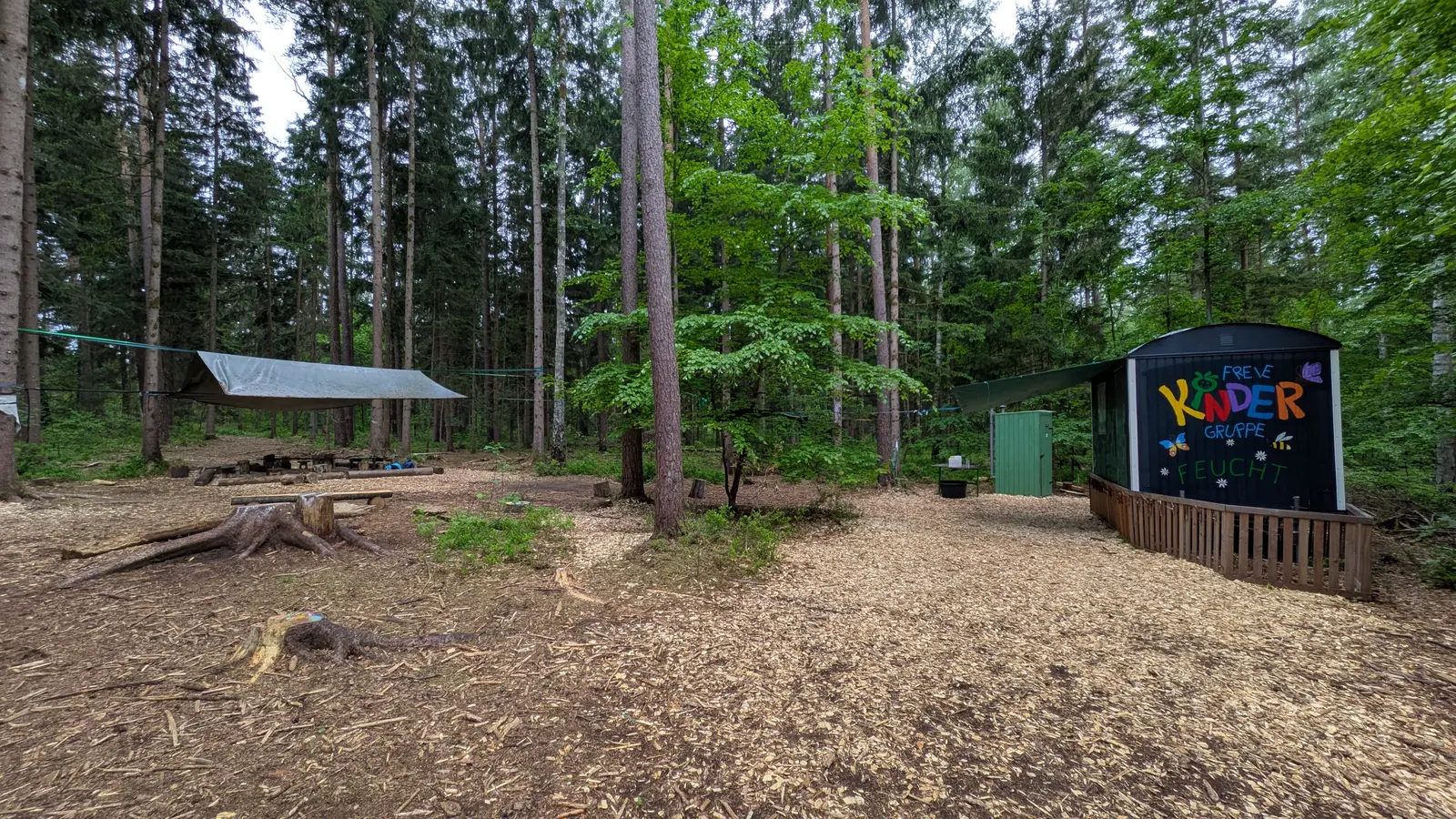 Unser Waldplatz mit Bauwagen und aufgespannter Plane